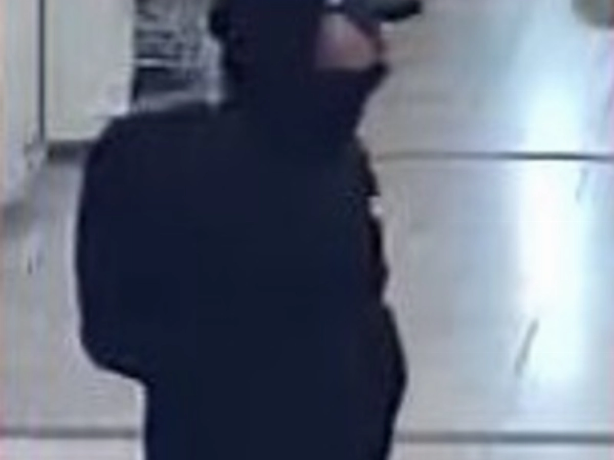 Politie toont beelden overvaller telefoonwinkel.