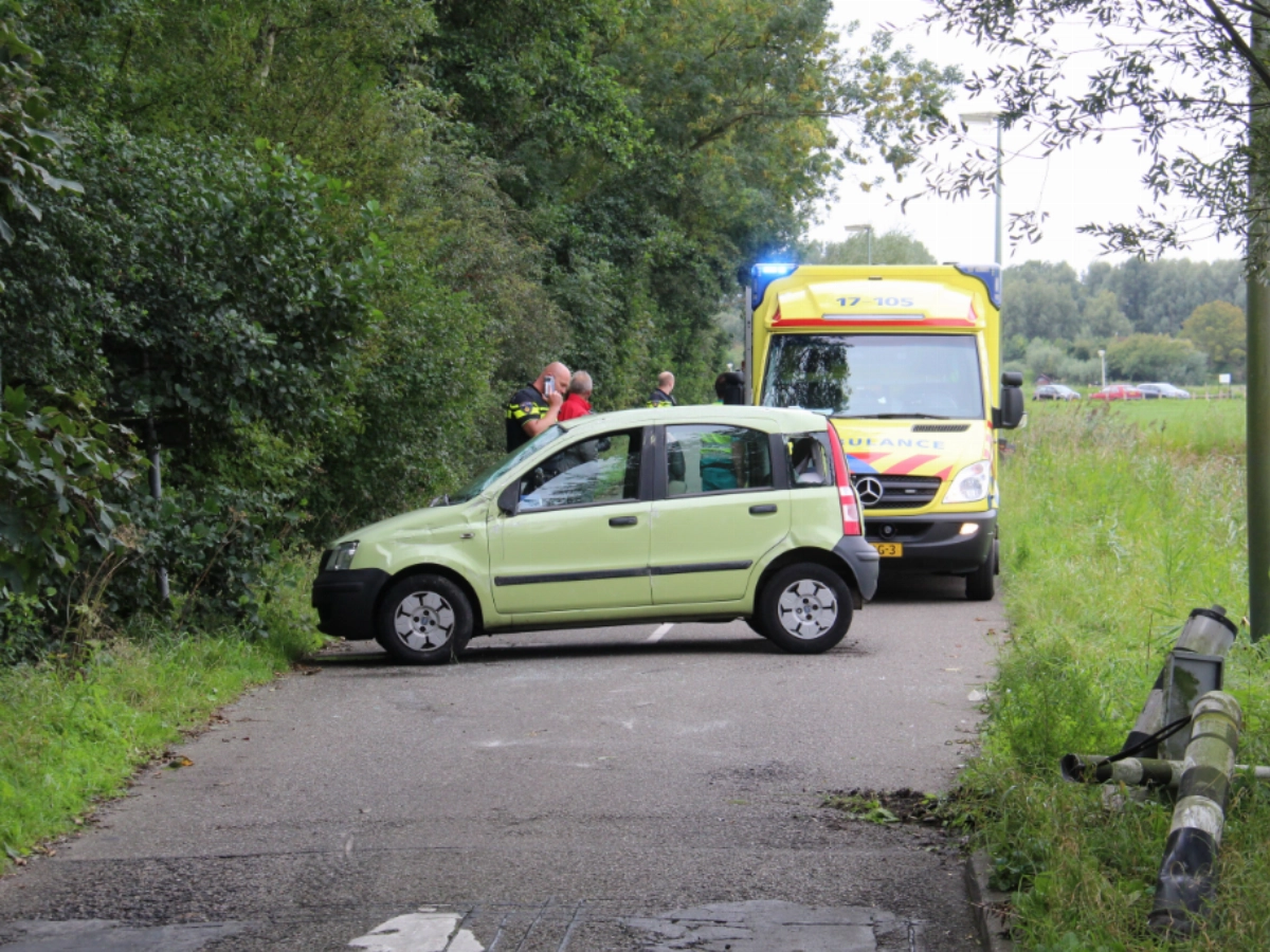 Auto op zijn kant; veel hulpverleners te hulp geroepen.