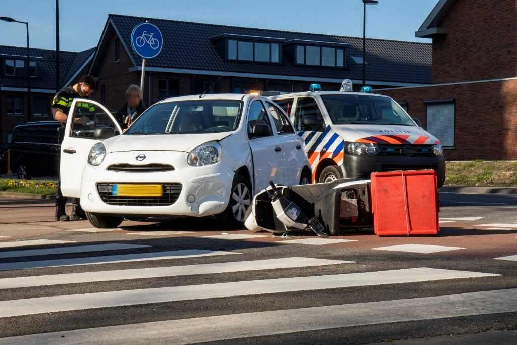Afslaande auto ziet scooter over het hoofd