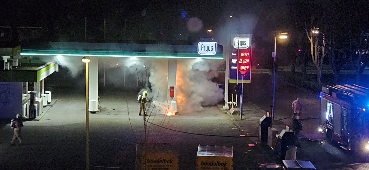 Scooter vat vlam naast benzinepomp bij tanken
