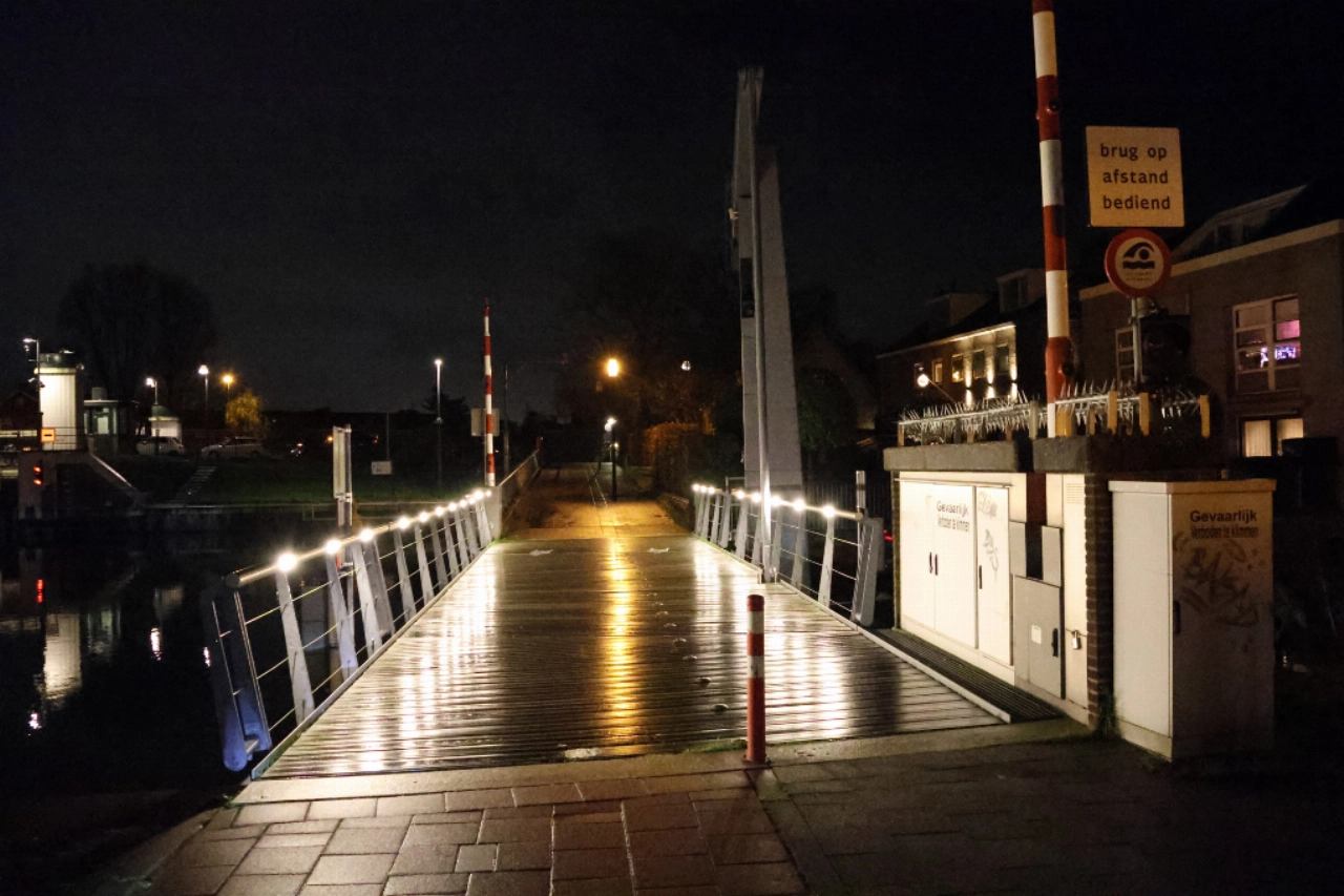 Scooterrijdster onderuit op gladde brug