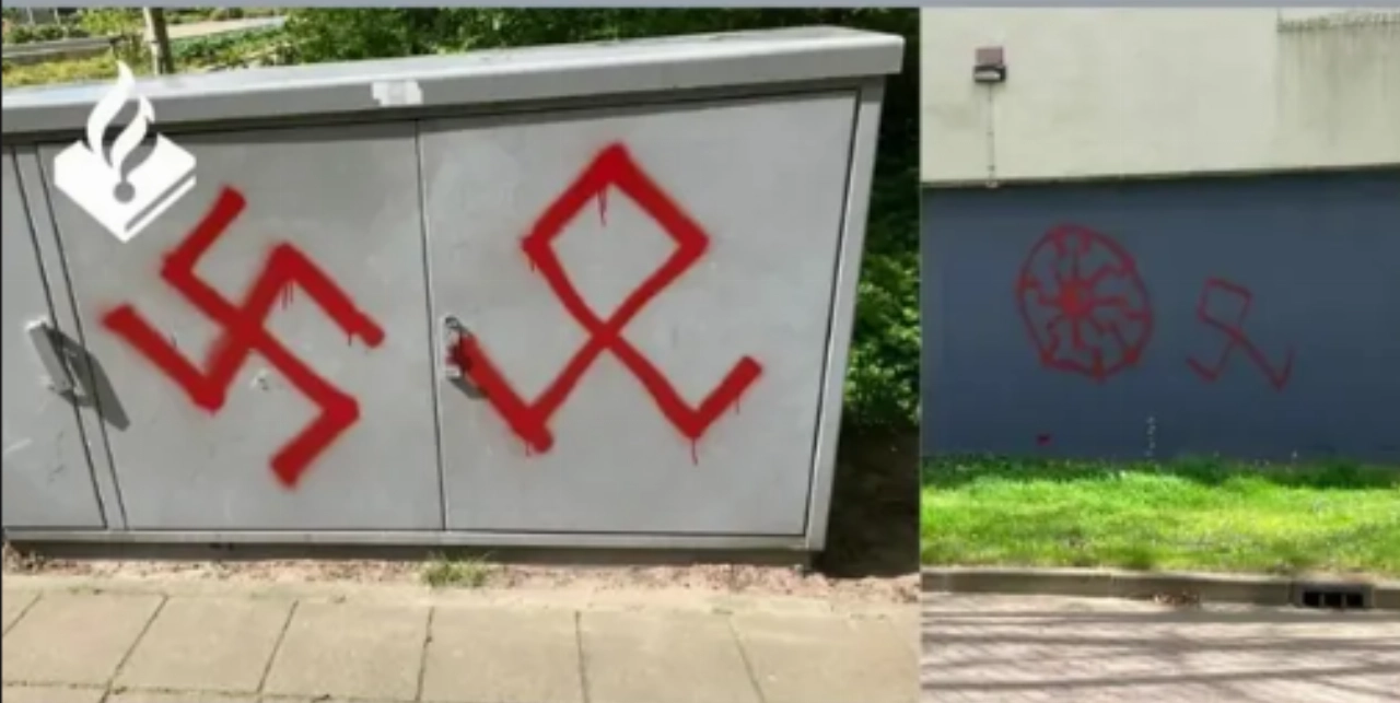 Gebouwen, bushaltes en monumenten beklad met hakenkruizen