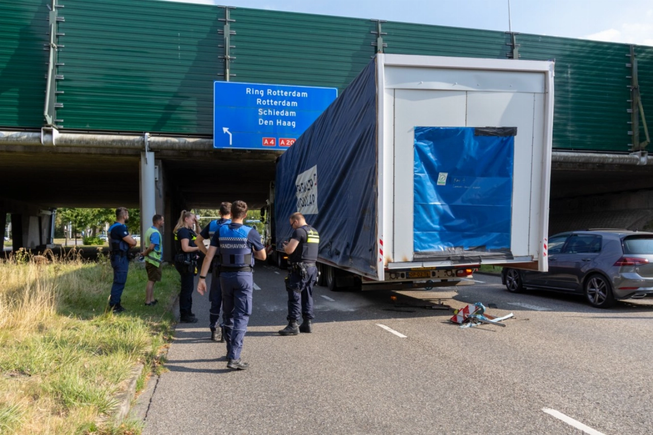 Te hoge vrachtwagen klem bij Holysingel