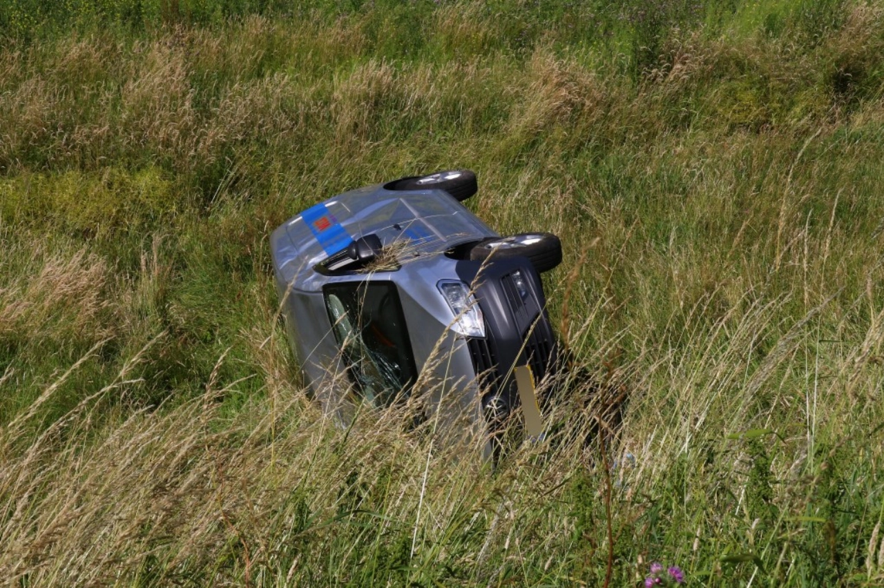 Auto rijdt van de dijk en slaat over de kop