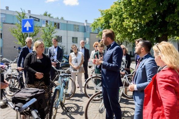 Minister De Jonge op de fiets door Schiedam-Oost