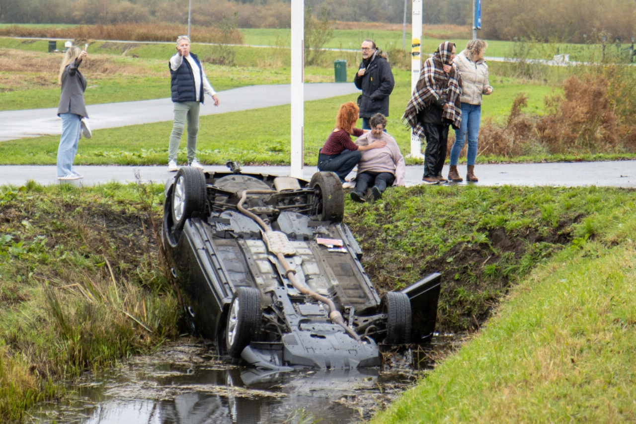 Auto op zijn kop in sloot