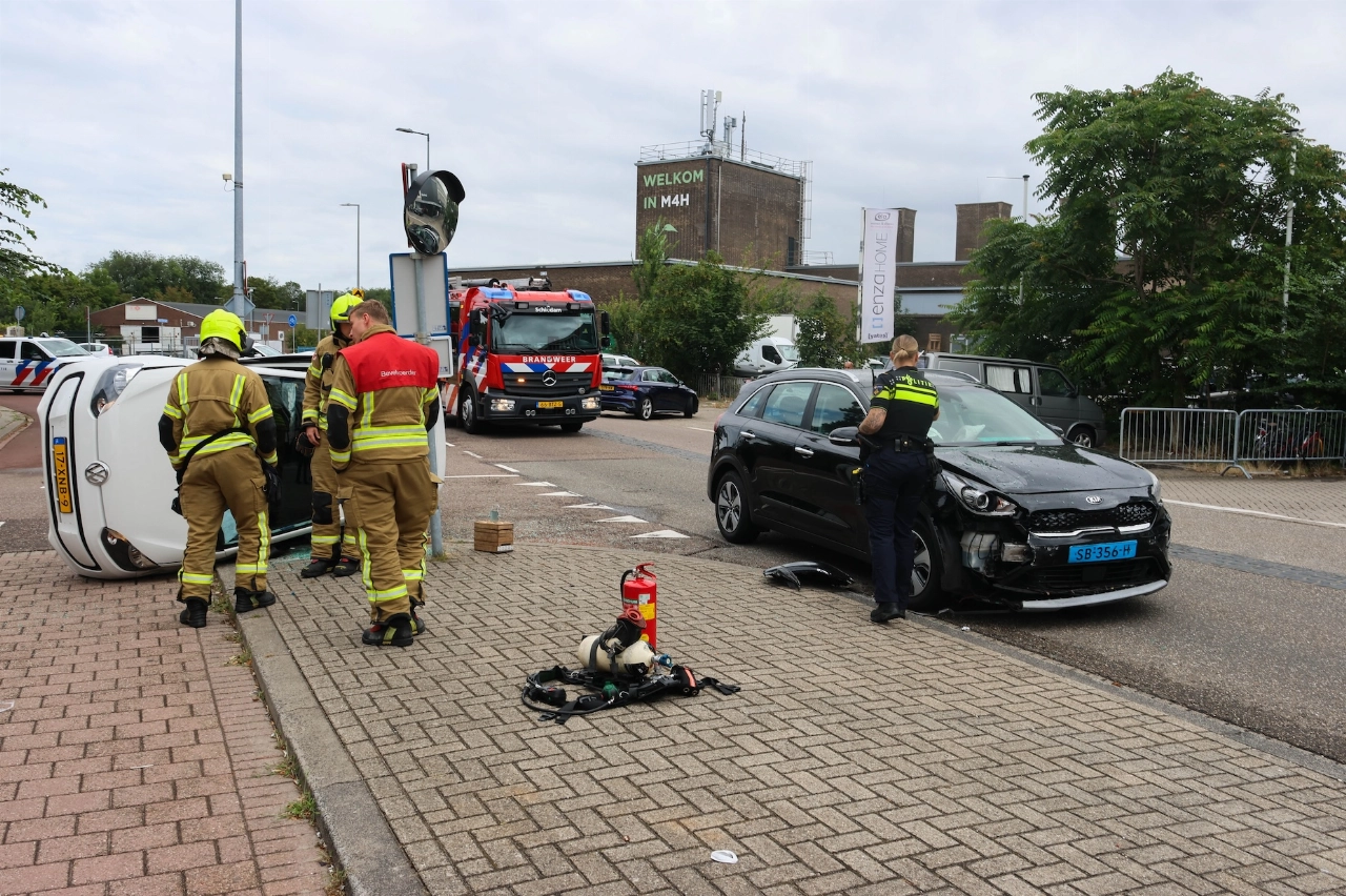 Auto op zijn kant na aanrijding met taxi