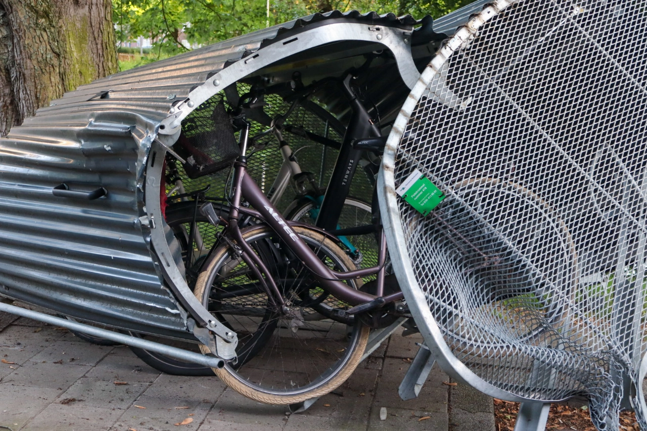 Automobilist knalt op fietsenstalling en vlucht