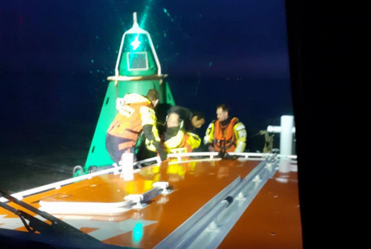 Kitesurfer in problemen kruipt op boei en belt 112