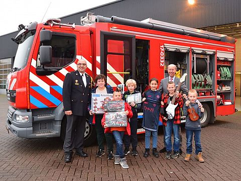 Prijswinnaars Kerstbomenactie op de foto met burgemeester en brandweer