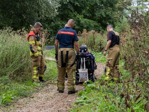 Elektrische rolstoel zakt weg op zacht pad, brandweer schiet te hulp