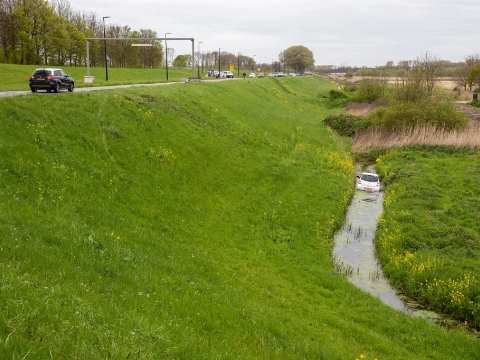 Auto de dijk af en de sloot in