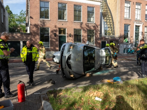 Auto gekanteld na botsing met geparkeerde auto