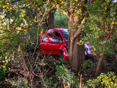 Auto op afrit uit bocht, tegen boom