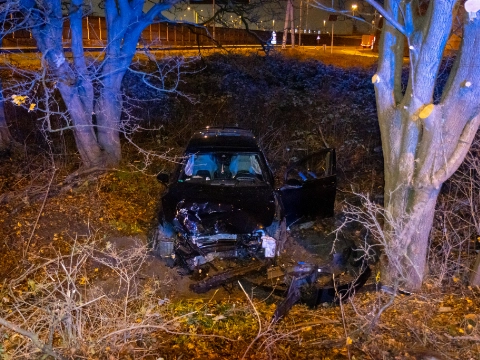 Auto van weg af, tegen boom
