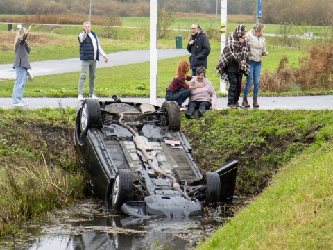 Auto op zijn kop in sloot