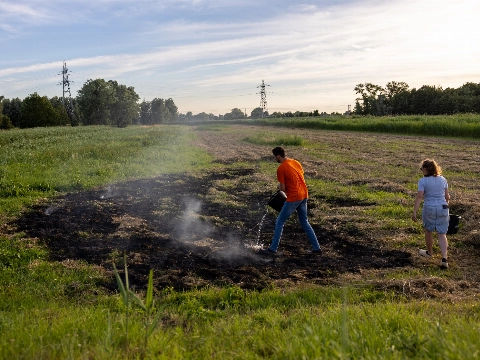 Omstanders blussen in brand gestoken hooi