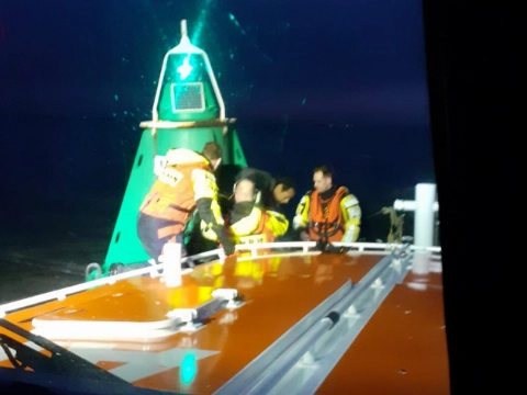 Kitesurfer in problemen kruipt op boei en belt 112